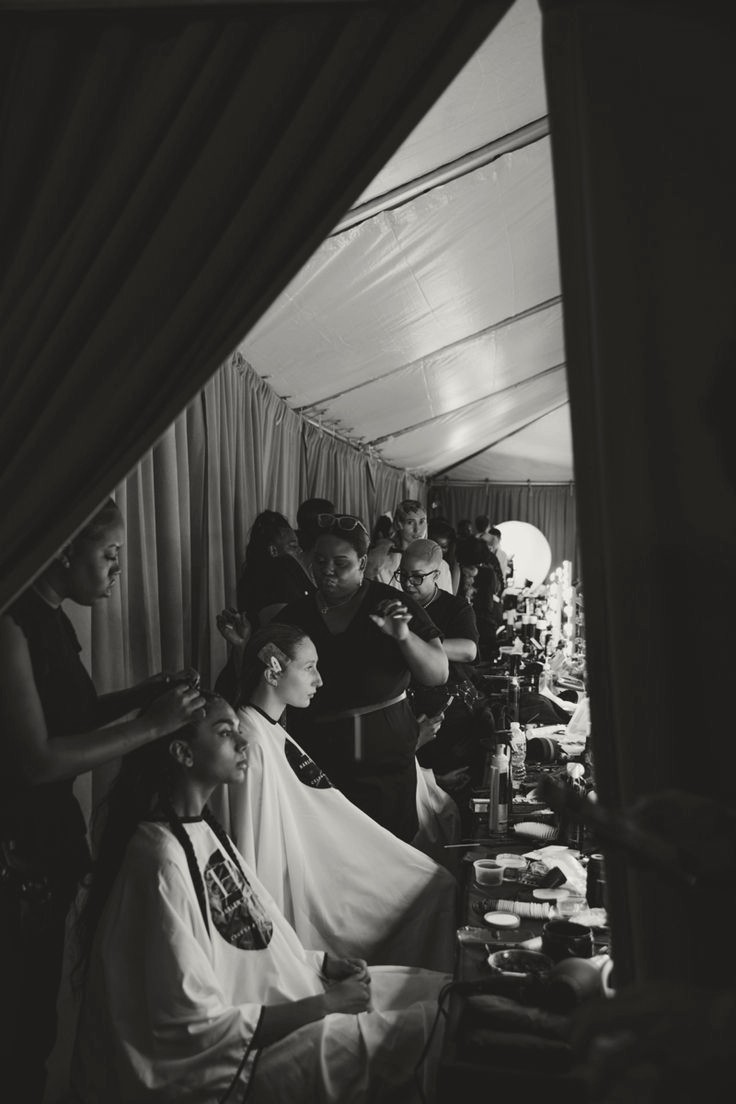 Beauty professionals preparing guests in a backstage glam suite