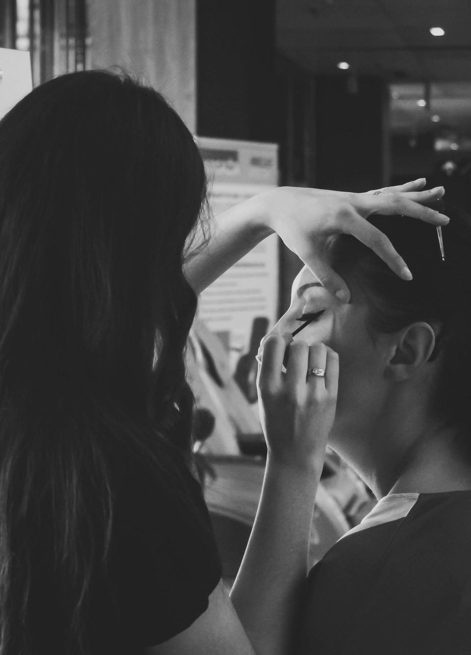 Makeup artist applying precise eye makeup backstage